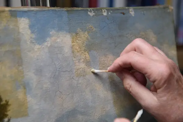 Detailreinigung eines Gemäldes mit Wattestäbchen im Berliner Atelier